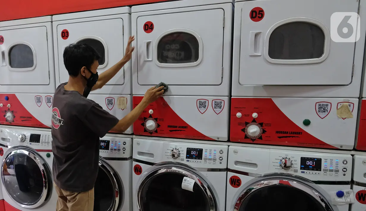 Pekerja membersihkan mesin cuci di gerai jasa layanan laundry, kawasan Kemang, Jakarta, Rabu (25/11/2020). Sejak tiga bulan terakhir omset mereka kembali membaik dan mengalami peningkatan sebesar 20 hingga 30 persen. (Liputan6.com/Herman Zakharia)