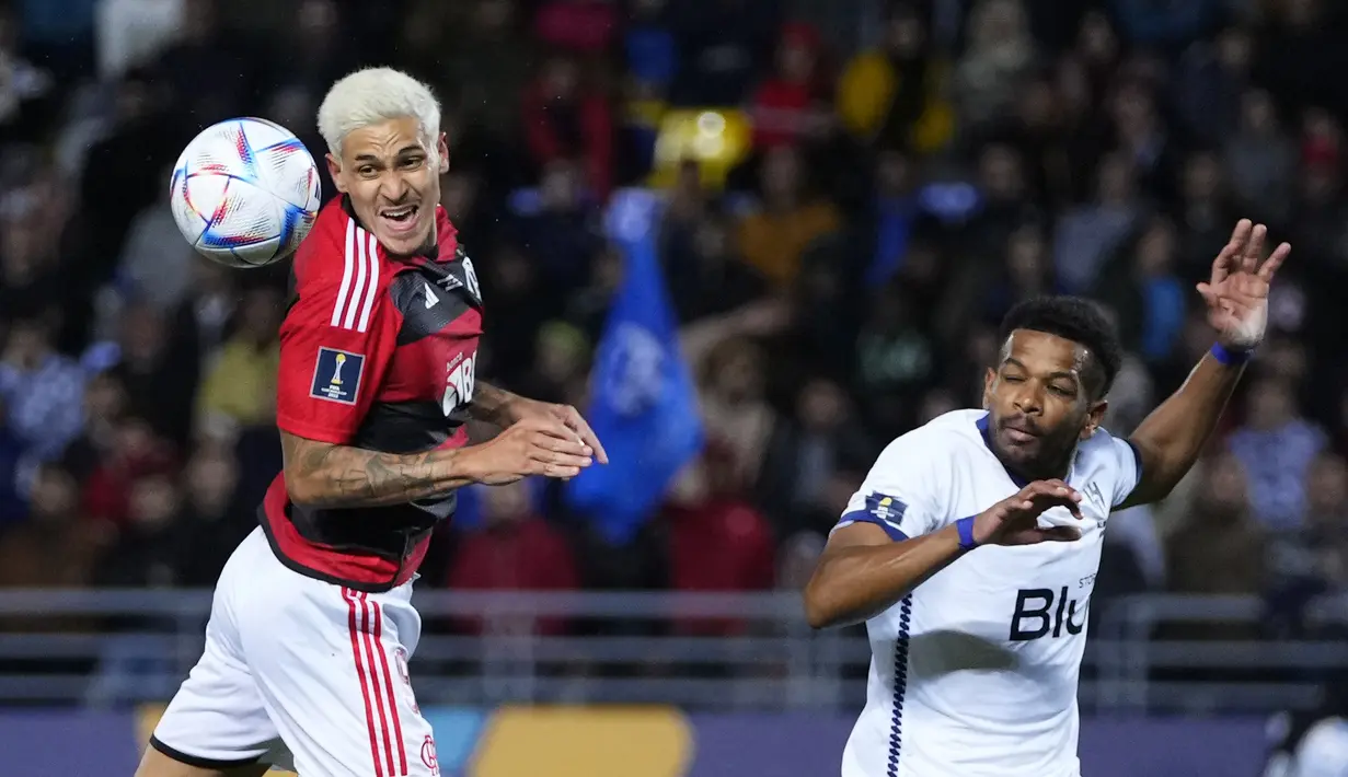 Penyerang Flamengo Pedro melompat untuk berebut bola dengan bek Al Hilal, Ali Albulayhi dalam duel babak semifinal Piala Dunia Antarklub 2022 di Ibn Batouta Stadium, Rabu (8/2/2023) dini hari WIB. Al Hilal merupakan wakil AFC, sementara Flamengo adalah juara Copa Libertadores. (AP Photo/Manu Fernandez)