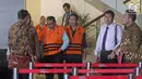 Tersangka anggota DPRD Malang Wiwik Hendri Astuti, M Zainudin dan Suprapto mengenakan rompi tahanan usai menjalani pemeriksaan di Gedung KPK, Jakarta, Rabu (28/3). 5 anggota DPRD Malang resmi ditahan atas dugaan suap APBD-P. (Liputan6.com/Herman Zakharia)