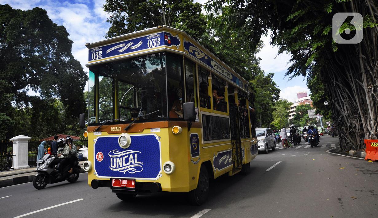 Bus wisata Uncal melintas di depan Balai Kota Bogor, Bogor, Jawa Barat, Minggu (29/5/2022). Bus wisata gratis yang disediakan untuk mengelilingi kawasan Kebun Raya Bogor setiap hari Sabtu dan Minggu ini mulai beroperasi kembali pascapandemi. (merdeka.com/Arie Basuki)