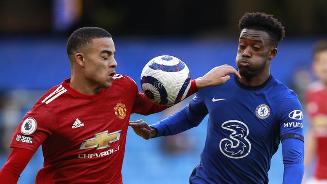 Penyerang Manchester United, Mason Greenwood (kiri) berebut bola dengan penyerang Chelsea, Callum Hudson-Odoi pada pertandingan lanjutan Liga Inggris di Stamford Bridge Stadium di London, Inggris, Minggu (28/2/2021). Chelsea bermain imbang atas MU 0-0. (Clive Rose/Pool via AP)