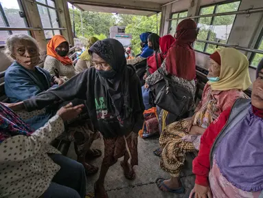 Warga  naik truk saat dievakuasi dari rumah mereka setelah letusan Gunung Merapi di Sleman, Yogyakarta (27/1/2021). Puluhan orang, sebagian besar lansia, tinggal dalam jarak beberapa kilometer dari kawah paling aktif di negara itu telah dievakuasi ke barak yang didirikan. (AP Photo/ Kasan Kurdi)