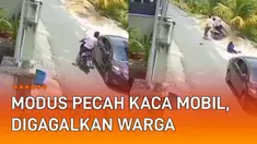 Aksi seorang pria memecahkan kaca mobil dan mencuri barang terjadi di pinggir jalan.