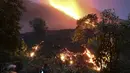 Orang-orang melihat aliran lava dari Gunung Berapi Pacaya Guatemala di desa Patrocinio, San Vicente Pacaya, sekitar 60 kilometer selatan kota Guatemala pada Kamis (25/3/2021). Sejak awal Februari 2021 lalu, aktivitas Gunung Pacaya dilaporkan terus aktif. (Johan ORDONEZ / AFP)