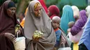 Sejumlah wanita Somalia berjalan sambil membawa iftar (makanan berbuka puasa) dari sebuah organisasi amal Qatar selama bulan suci Ramadan, di ibukota Mogadishu, Senin (22/6/2015). (REUTERS/Feisal Omar)