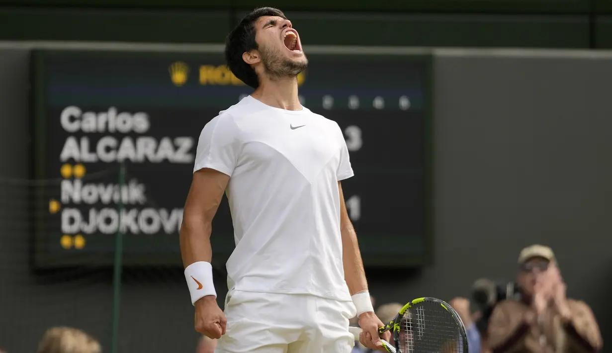 Selebrasi petenis Spanyol, Carlos Alcaraz setelah meraih poin saat menghadapi petenis Serbia, Novak Djokovic pada laga final tunggal putra turnamen tenis Grand Slam Wimbledon 2023 di All England Lawn and Tennis Club, London, Minggu (16/7/2023) malam WIB. (AP Photo/Kirsty Wigglesworth)