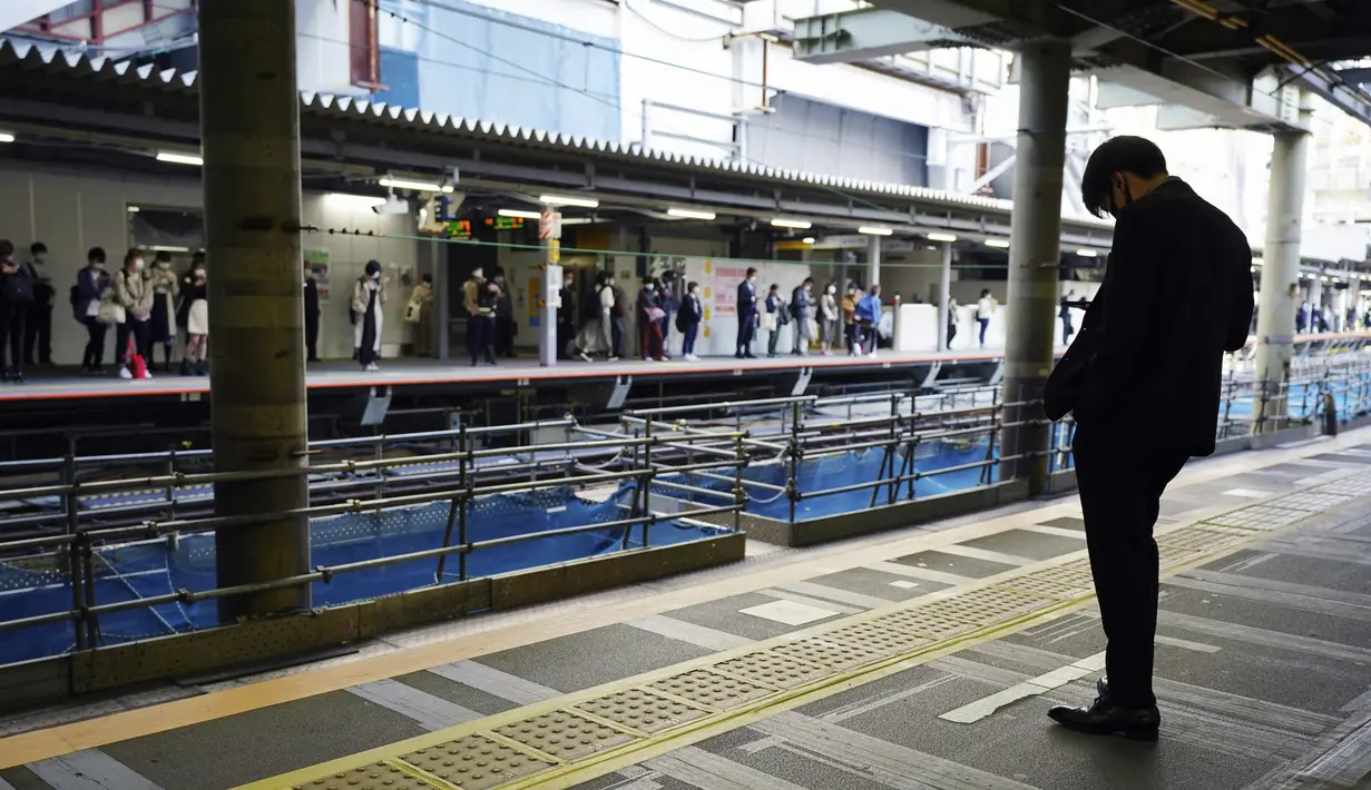 Seorang pria yang mengenakan masker pelindung untuk membantu mengekang penyebaran virus corona COVID-19 menunggu kereta di Tokyo, Jepang, Rabu (7/4/2021). Tokyo mengonfirmasi lebih dari 550 kasus COVID-19 baru pada 7 April 2021. (AP Photo/Eugene Hoshiko)
