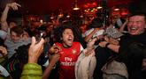 Suka cita menyelimuti para suporter Arsenal setelah The Gunners memastikan diri sebagai juara Liga Inggris musim 2025/2026. (AP Photo/Alberto Pezzali)