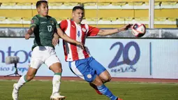 Pemain Bolivia Roberto Fernandez (kiri) berebut bola dengan pemain Paraguay Fabián Balbuena pada pertandingan kualifikasi Piala Dunia 2022 di Stadion Hernando Siles, La Paz, Bolivia, Kamis (14/10/2021). Bolivia menang 4-0. (Javier Mamani/Pool via AP)