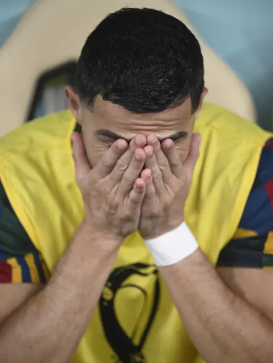 Reaksi Cristiano Ronaldo saat menyaksikan timnya dari bangku cadangan selama pertandingan sepak bola babak 16 besar Piala Dunia 2022 antara Portugal dan Swiss di Stadion Lusail, Lusail, Qatar, Selasa (6/12/2022). Meski tidak ada Ronaldo sebagai pemain inti, Portugal mampu mengalahkan anak buah Murat Yakin dengan skor 6-1 dan maju ke perempat final. (PATRICIA DE MELO MOREIRA / AFP)