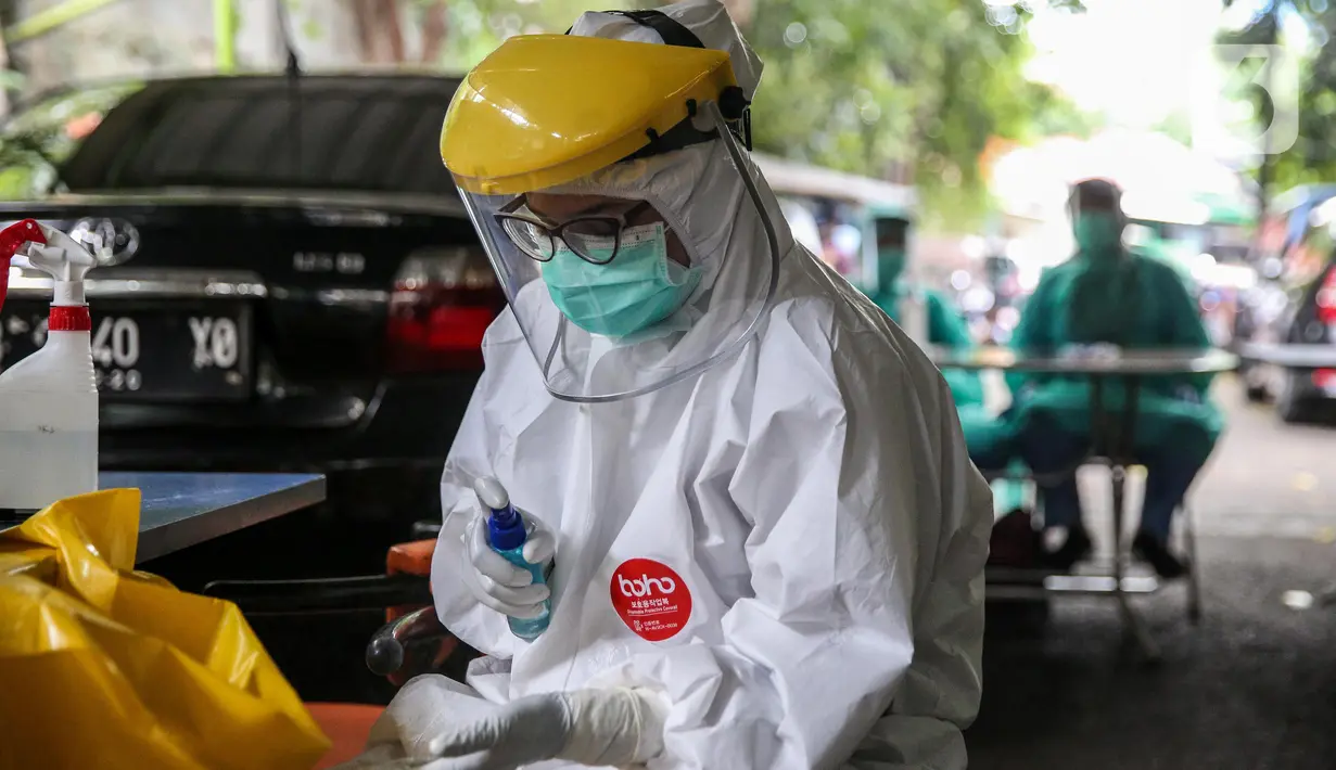 Petugas Puskesmas Kecamatan Gambir menyemprotkan cairan disinfektan saat menggelar Swab Test COVID 19 di kawasan jalan Juanda, Jakarta, Selasa (16/6/2020).  Tes Swab untuk mencari warga positif Covid-19 tanpa gejala ini menyasar petugas PPSU dan pedagang Pasar Ceylon. (Liputan6.com/Faizal Fanani)