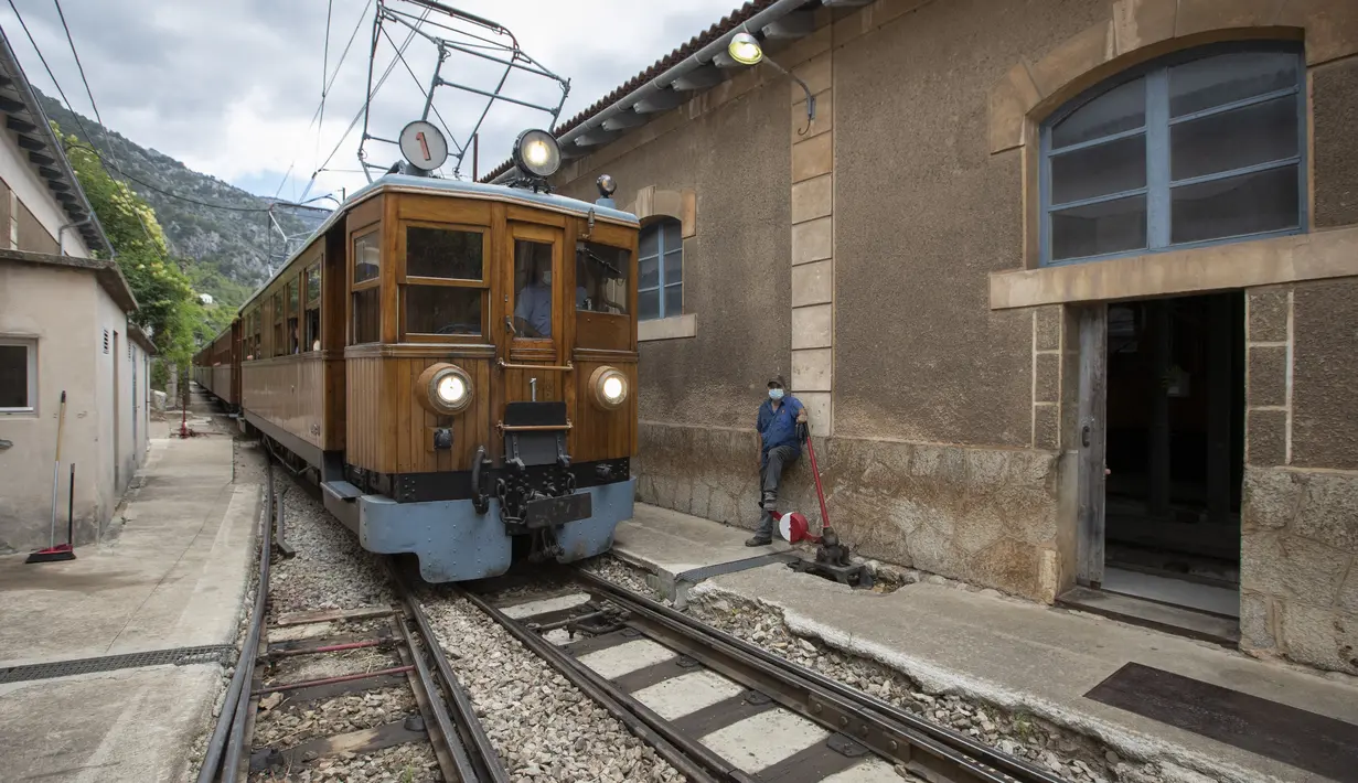 Kereta api Palma-Soller tiba di stasiun Soller di Pulau Balearic Spanyol Mallorca (14/7/2021). Diresmikan pada tahun 1912, jalur kereta api Palma-Soller adalah salah satu rute tertua yang masih beroperasi di Spanyol. (AFP/Jaime Reina)