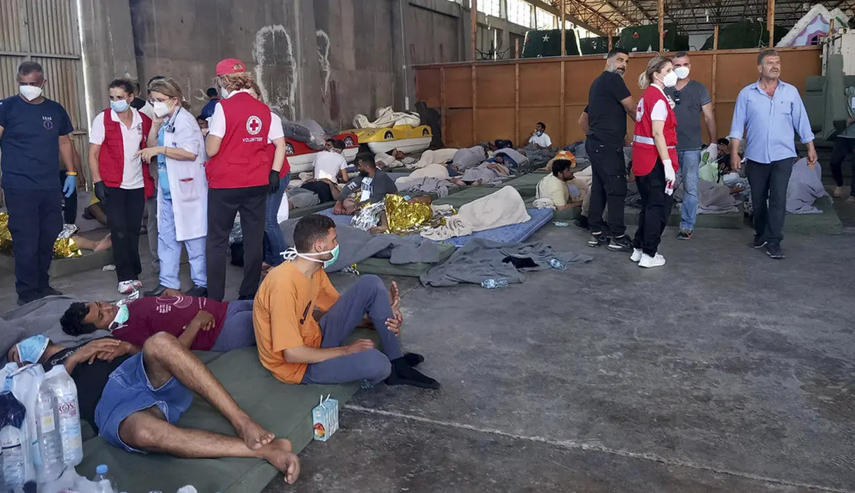 <p>Para penyintas dibawa ke pelabuhan Yunani Kalamata dekat Pylos. Dengan berselimut, mereka beristirahat di kasur di gudang penampungan, dan kementerian migrasi diharapkan memindahkan mereka ke kamp di luar Athena. (www.argolikeseidhseis.gr via AP)</p>