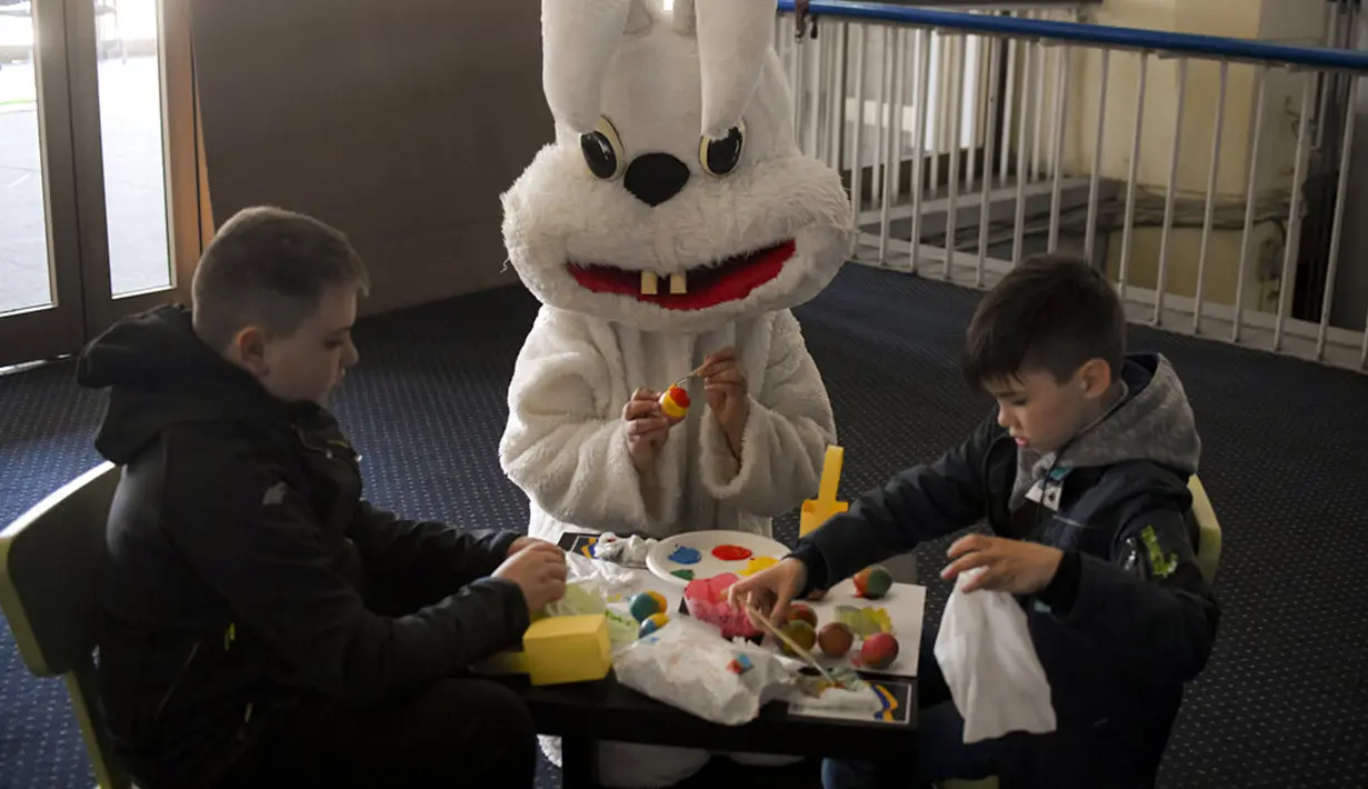 <p>Pengungsi anak-anak Ukraina melukis telur Paskah pada Kamis Putih di sebuah pusat pengungsi di Bucharest, Rumania, 21 April 2022. Orang Rumania yang mayoritas jemaat Ortodoks merayakan Minggu Paskah pada 24 April. (AP Photo/Andreea Alexandru)</p>