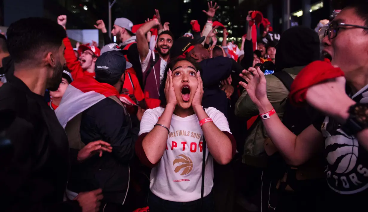 Ekspresi penggemar saat merayakan kesuksesan Toronto Raptors menjuarai NBA 2018-2019, Jumat (14/6/2019) pagi WIB. Kemenangan tersebut memicu kegemparan di Kanada. (Nathan Denette/The Canadian Press via AP)
