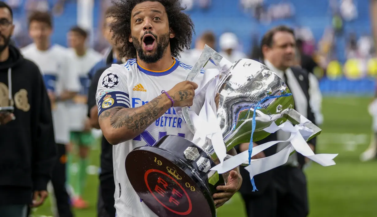<p>Bek Real Madrid, Marcelo berpose dengan trofi untuk merayakan gelar La Liga Spanyol usai pertandingan melawan Espanyol di stadion Santiago Bernabeu di Madrid, Sabtu (30/4/2022). Ini adalah gelar juara LaLiga ke-35 sepanjang sejarah klub ini. (AP Photo/Bernat Armangue)</p>