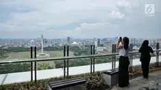 Pengunjung mengambil gambar pemandangan Monas dari atas Perpustakaan Nasional RI di Jakarta, Senin (6/11). Perpustakaan Nasional Indonesia (Perpusnas) yang baru ini di diresmikan Presiden Jokowi Pada 14 September 2017 lalu. (Liputan6.com/Faizal Fanani)