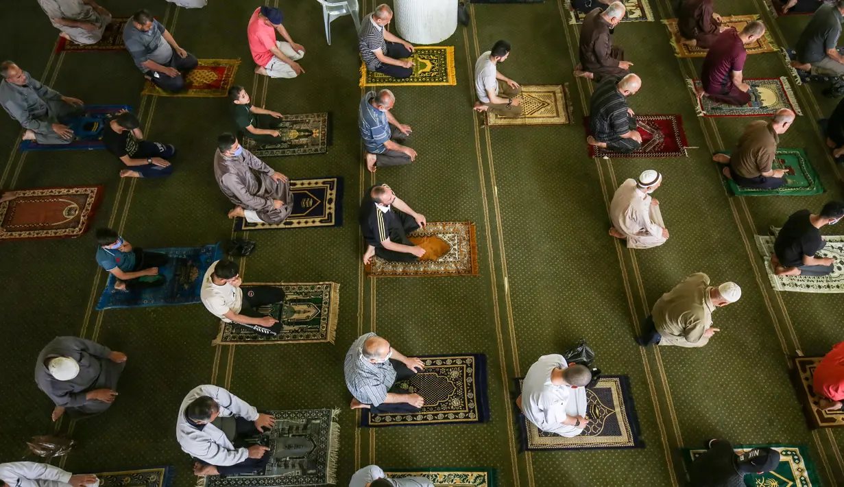 Orang-orang Palestina menjaga jarak ketika mereka ikut serta dalam salat zuhur di masjid Al-Abrar di Rafah, selatan Jalur Gaza, Rabu (3/6/2020). Masjid-masjid kembali dibuka bagi jemaah menyusul pelonggaran pembatasan Covid-19 di Jalur Gaza. (Photo by SAID KHATIB / AFP)