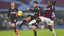 Pemain Liverpool, Nathaniel Phillips, berebut bola dengan pemain West Ham United, Michail Antonio, pada laga Liga Inggris di Stadion London, Minggu (31/1/2021). Liverpool menang dengan skor 3-1. (Justin Setterfield/Pool via AP)