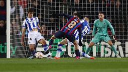 Pedri dari Barcelona (tengah) mengontrol bola dari kawalan dua pemain Real Sociedad, Robin Le Normand dan Diego Rico pada pertandingan perempatfinal Copa del Rey di stadion Camp Nou, di Barcelona, Spanyol, Kamis (26/1/2023). Kemenangan ini mengantar Barcelona melaju ke semifinal. (AP Photo/Joan Monfort)