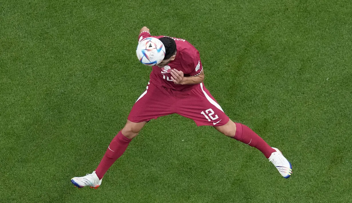 Gelandang Qatar, Karim Boudiaf menyundul bola saat bertanding melawan Ekuador pada pertandingan grup A Piala Dunia 2022 di Stadion Al Bayt di Al Khor, Qatar, Minggu (20/11/2022). Ekuador menang atas Qatar 2-0. (AP Photo/Thanassis Stavrakis)