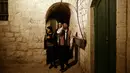 Kelompok pemuda Palestina berpakaian tradisional berteriak membangunkan kaum muslim untuk sahur di Kota Tua Yerusalem, Selasa (5/6). Mereka menyusuri jalan-jalan kota, masuk ke gang-gang kecil di sudut-sudut permukiman warga. (AP/Mahmoud Illean)