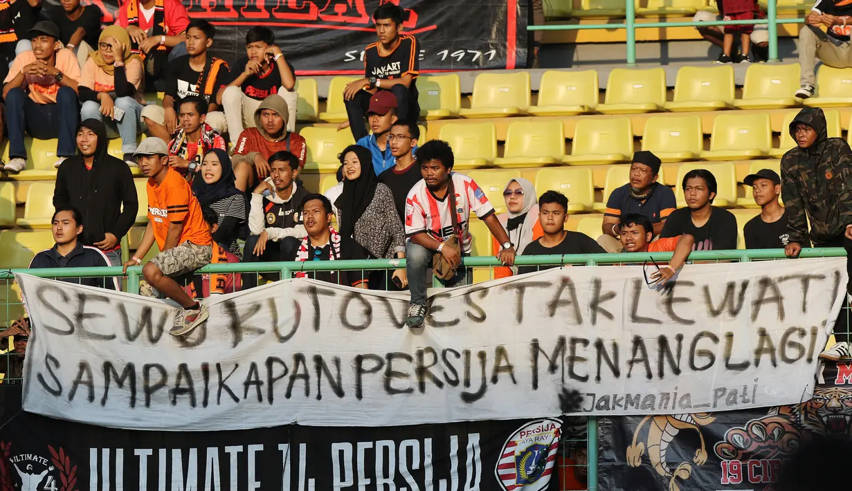 Suporter Persija Jakarta memasang spanduk protes saat pertandingan melawan Perseru Badak Lampung pada laga Liga 1 2019 di Stadion Patriot, Bekasi, Minggu (1/9). Persija takluk 0-1 dari Badak Lampung. (Bola.com/M Iqbal Ichsan)