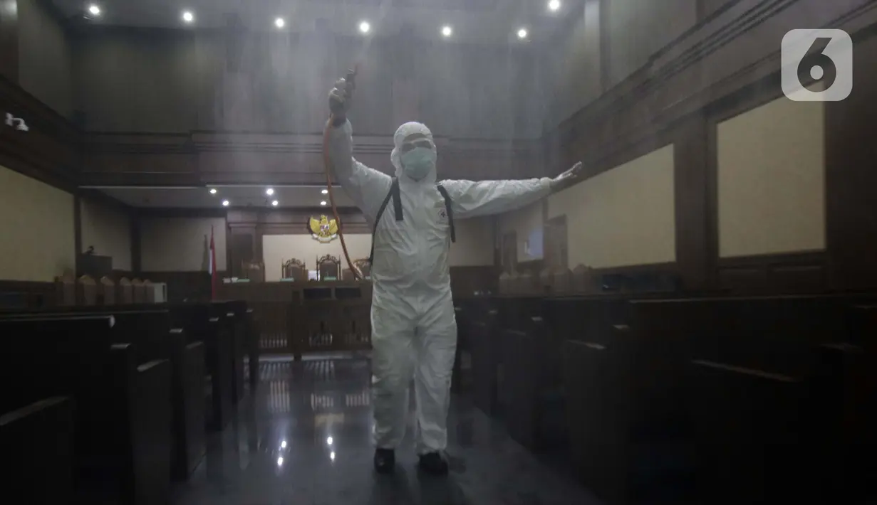 Petugas Palang Merah Indonesia saat melakukan penyemprotan cairan disinfektan di salah satu ruang sidang Pengadilan Negeri Jakarta Pusat, Rabu (18/3/2020). Penyemprotan cairan disinfektan untuk mencegah penyebaran virus corona COVID-19. (Liputan6.com/Helmi Fithriansyah)