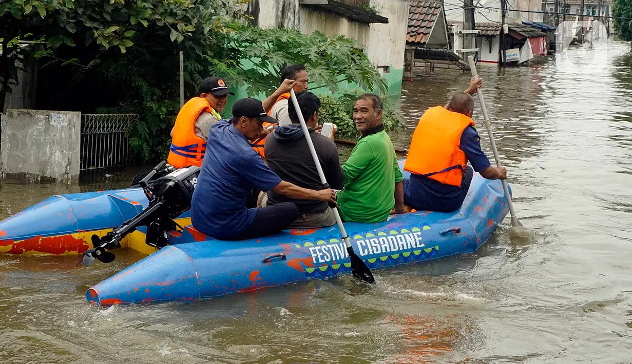 Warga menggunakan perahu karet melintasi banjir yang melanda Perumahan Total Persada, Periuk, Kota Tangerang, Selasa (4/2/2020). Banjir akibat tanggul kali Ledug jebol membuat ratusan rumah di Total Persada terendam banjir hingga mencapai 3,5 meter. (merdeka.com/Arie Basuki)