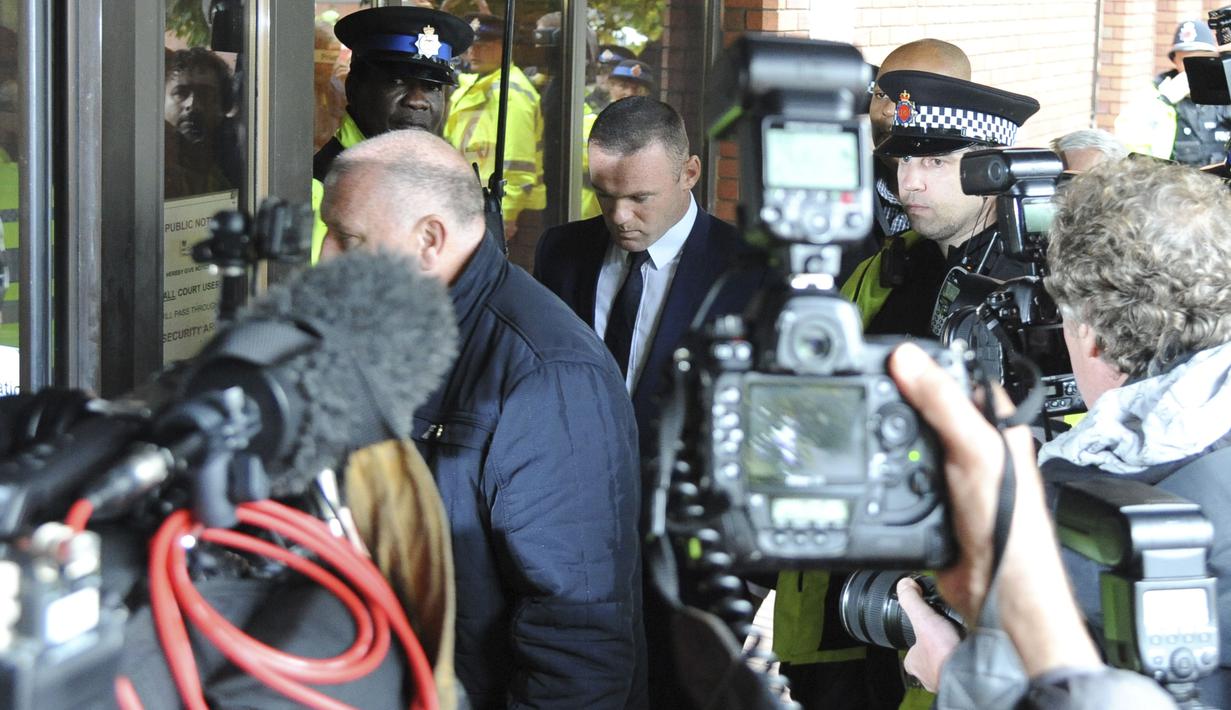Wayne Rooney (tengah) hanya tertunduk saat memenuhi panggilan pengadilan Stockport Magistrates di Stockport, Inggris, (18/9/2017). Kehadiran Rooney di pengadilan karena kedapatan mengemudi saat mabuk. (AP/Rui Vieira)