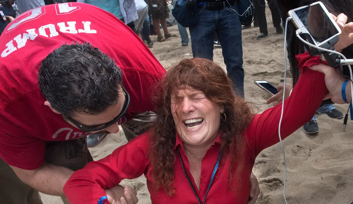 Seorang penyelenggara dan pendukung Trump, Jennifer Sterling kesakitan setelah matanya terkena semprotan lada oleh pengunjuk rasa anti-Trump di Huntington Beach, California (25/3). (Mindy Schauer / The Orange County Register via AP)
