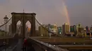 Warga beraktivitas saat pelangi terlihat dari Jembatan Brooklyn di New York City, AS (15/5). Jembatan ini selesai dibangun 1883 dan menghubungkan borough Manhattan dan Brooklyn di New York City melintasi Sungai East. (AFP Photo/Hector Retamal)
