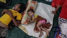 Seorang ayah dan putrinya tengah tertidur di kelas SD Kristen Fajar Sion, Jakarta Barat, Minggu (8/1). Sebanyak 110 rumah di pemukiman padat penduduk di Jalan Pangeran Jayakarta habis dilalap si jago merah. (Liputan6.com/Fery Pradolo)