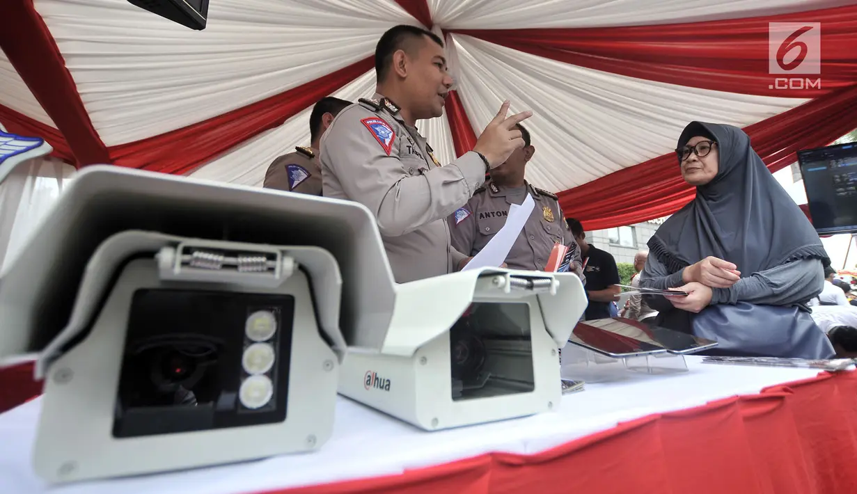 Polisi menyosialisasikan sistem Electronic Traffic Law Enforcement (ETLE) kepada warga di kawasan Bundaran HI, Jakarta, Minggu (25/11). Sistem ETLE menggunakan kamera berteknologi canggih. (Merdeka.com/Iqbal Nugroho)