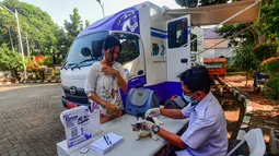 Dokter hewan melakukan penyuntikan vaksin anti rabies kucing peliharaan warga pada unit mobil Klinik Hewan Keliling di halaman Kantor Kelurahan Srengseng sawah, Jakarta Selatan, Rabu, 15/ Juli 2026. (KLY/ Arie Basuki)