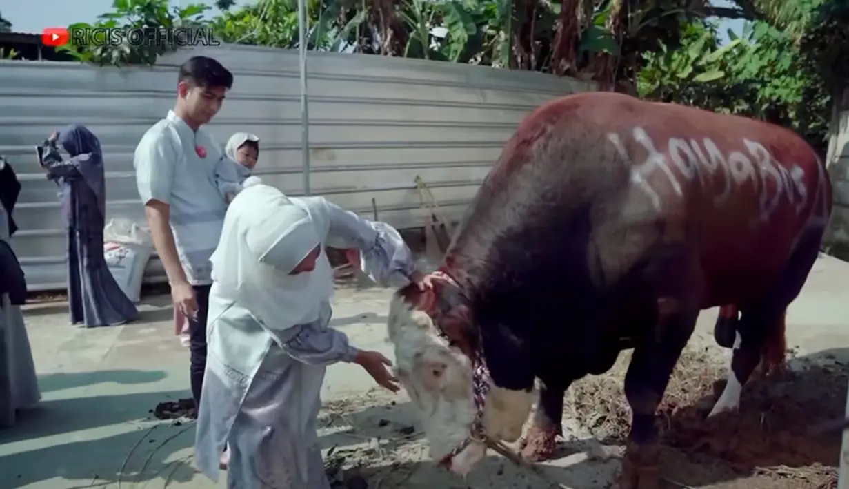 Ricis bersama suami dan anaknya saat akan menyaksikan hewan kurbannya. Dalam video di kanal Youtubenya, Ricis tampak bicara dengan sapinya sambil  terisak. [Youtube/Ricis Official]