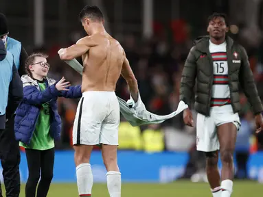 Sebuah momen manis terekam usai laga imbang antara Republik Irlandia melawan Portugal pada Kualifikasi Piala Dunia 2022. Cristiano Ronaldo terlihat memberikan pelukan dan jersey kepada fans ciliknya yang berasal dari Irlandia. (AP/Peter Morrison)