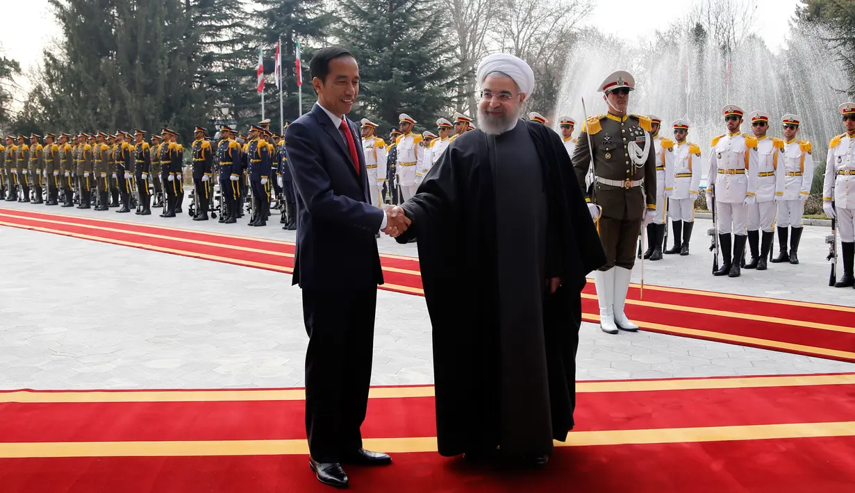 Presiden Joko Widodo berjabat tangan dengan Presiden Hassan Rouhani saat tiba di Istana Saadabad, Rabu (14/12). Dalam kunjungannya, Jokowi juga menghadiri jamuan makan siang. (AFP Photo/Atta Kenare)