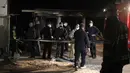 Petugas pemadam kebakaran dan polisi berdiri di dekat rumah sakit darurat yang terbakar di kota Tetovo, Makedonia Utara, Kamis (9/9/2021). Belum diketahui penyebab kebakaran, penyelidikan masih berlangsung. (AP Photo/Boris Grdanoski)