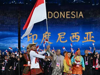 Kontingen Indonesia mengikuti defile saat upacara pembukaan  Opening Ceremony Asian Games 2023 Hangzhou di Hangzhou Olimpic Sports Centre, China, Sabtu (23/9/2023). (WILLIAM WEST / AFP)