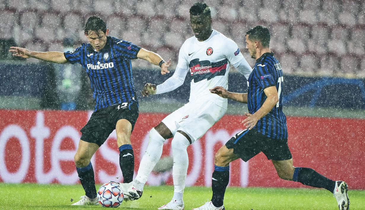 Gelandang Atalanta, Remo Freuler, berebut bola dengan penyerang Midtjylland, Sory Kaba, pada laga Grup D Liga Champions 2020/2021 di MCH Arena, Kamis (22/10/2020) dini hari WIB. Atalanta menang telak 4-0 atas Midtjylland. (AFP/Henning Bagger/Ritzau Scanpix)