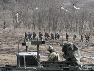 Tentara Korea Selatan berbaris ketika seorang tentara AS duduk di kendaraan militer selama latihan militer bersama di Paju, Korea Selatan, Kamis, 16 Maret 2023. (AP Photo/Lee Jin-man)
