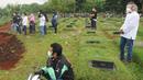 Keluarga menyaksikan pemakaman korban COVID-19 di TPU Pondok Ranggon, Cipayung, Jakarta Timur, Rabu (1/4/2020). Hari ini di TPU Pondok Ranggon hingga menjelang sore hari tercatat sembilan belas jenazah dimakamkan baik yang berstatus ODP, PDP  maupun postif  COVID-19. (merdeka.com/Arie Basuki)