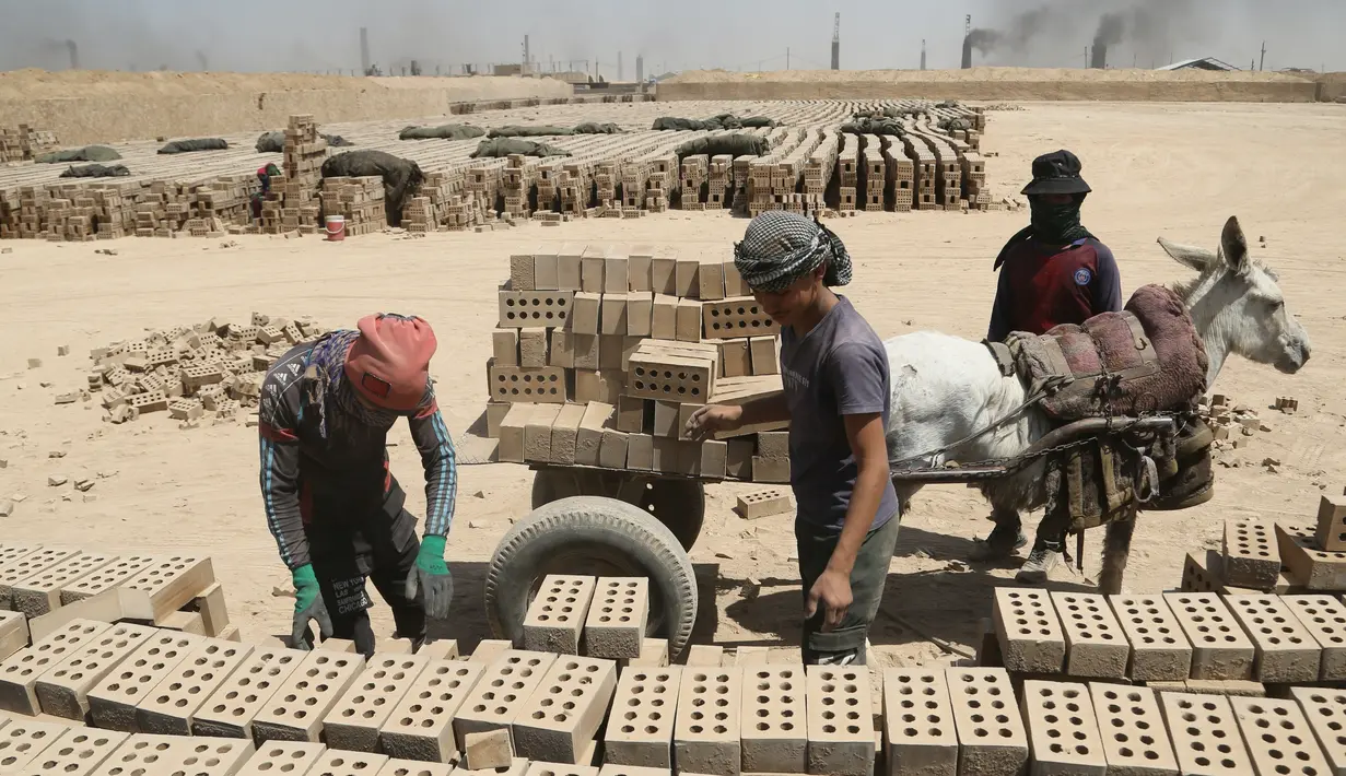 Pria bekerja di pabrik batu bata di pabrik batu bata di pinggiran tenggara Baghdad Nahrawan, Irak, Kamis (24/5/2021).  Para pekerja bekerja 12 jam sehari dengan upah sekitar USD$ 15. (AP Photo/Hadi Mizban)