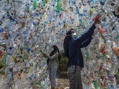 Aktivis Ecological Observation and Wetland Conservation (Ecoton) membuat instalasi yang terbuat dari sampah plastik di Gresik, Jawa Timur, 17 September 2021. Instalasi tersebut untuk meningkatkan kesadaran masyarakat akan sampah plastik di sungai dan lautan. (JUNI KRISWANTO/AFP)