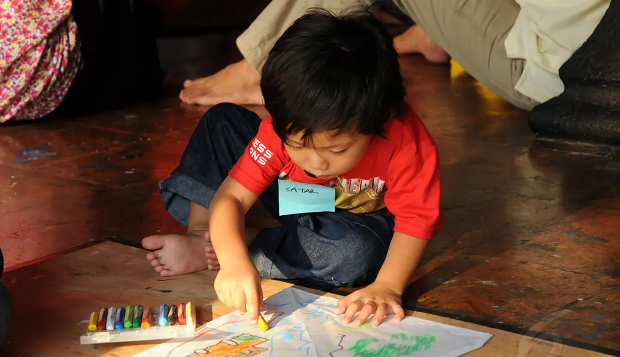 Salah satu anak menggambar di atas layang-layang buatannya di Museum Layang-Layang, Jakarta, (27/9/2014). (Liputan6.com/Helmi Fithriansyah)