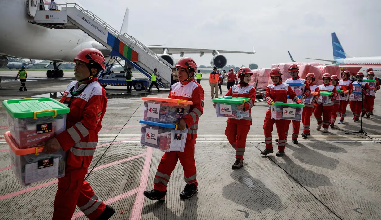 Personel Palang Merah Indonesia (PMI) membawa kotak-kotak berisi bahan bantuan setelah upacara keberangkatan misi bantuan kemanusiaan Indonesia ke Myanmar di Pangkalan Udara Halim Perdanakusuma, Jakarta, 3 April 2025. (YASUYOSHI CHIBA/AFP)