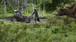 Seorang petani membajak sawah Kuta Cot Glie, provinsi Aceh (6/1/2022). Kementerian Keuangan menaikkan tarif CHT terhitung 1 Januari 2022 rata-rata 12 persen dengan dasar pertimbangan untuk pengendalian konsumsi rokok masyarakat. (AFP/Chaideer Mahyuddin)