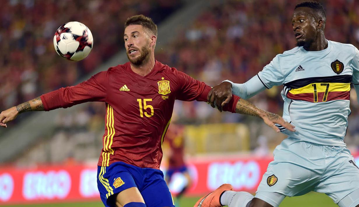 Bek Spanyol, Sergio Ramos, berusaha menahan pergerakan striker Belgia, Divock Origi. Spanyol menguasai jalannya laga dengan penguasaan bola 61 persen. (Reuters/Eric Vidal)