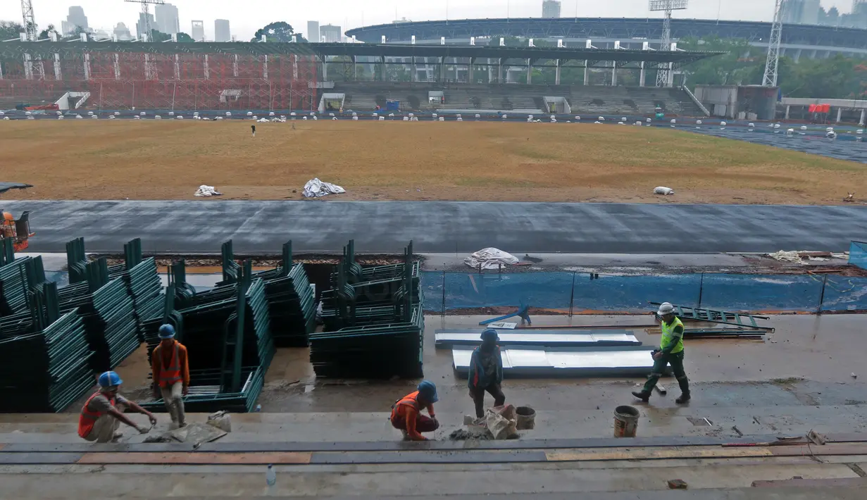 Pekerja sedang melakukan renovasi tribun venue Atletik Stadion Madya di Kawasan Senayan Sport Center, Jakarta (12/10/2017). Renovasi stadion tersebut untuk menyambut Asian Games 2018. (Bola.com/Nicklas Hanoatubun)